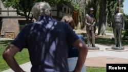 Visitantes miran las estatuas de Robert Oppenheimer, físico atómico y director del Laboratorio de Los Álamos durante la Segunda Guerra Mundial, y el general Leslie Groves, comandante general del Distrito de Ingenieros de Manhattan en Los Álamos, Nuevo México, EEUU, 30 de julio de 2023. REUTERS/Brian Snyder