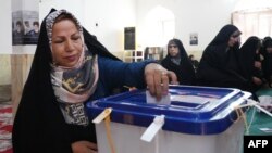 An Iranian woman casts her ballot at a polling station during presidential election in Tehran on June 28, 2024.