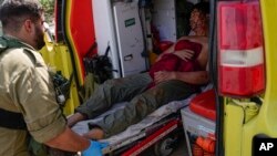 Israeli security forces in Kiryat Shoma, northern Israel, evacuate a wounded Thai man after he was hit by an anti-tank missile fired from Lebanon, in a nearby village on March 4, 2024.