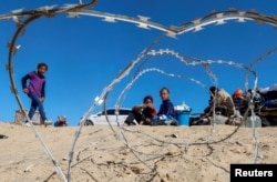 Palestinians sit to next to belongings as people flee Rafah after Israeli forces launched a ground and air operation in the eastern part of the southern Gaza city, May 9, 2024.