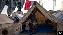 Palestinian children displaced by the Israeli bombardment of the Gaza Strip stand in a U.N. Development Program-provided tent camp in Khan Younis, Oct. 19, 2023. 