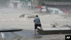 A resident looks at floodwaters in the Miaofengshan region on the outskirts of Beijing, Aug. 1, 2023.