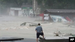 A resident looks at floodwaters in the Miaofengshan region on the outskirts of Beijing, Aug. 1, 2023.