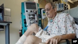 In this image from video provided by the University of Maryland School of Medicine, Lawrence Faucette, a pig heart transplant patient, works with a physical therapist at the school's hospital in Baltimore, Oct. 18, 2023. 