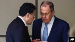 Russian Foreign Minister Sergey Lavrov and Chinese Foreign Minister Qin Gang talk on the sideline of a ministerial meeting in Samarkand, Uzbekistan, April 13, 2023. (Russian Foreign Ministry Press Service via AP)
