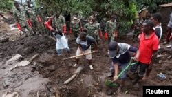 FILE - Members of the community and the Malawian army recover victims' bodies in Chimwankhunda township in the aftermath of Cyclone Freddy in Blantyre, Malawi, March 17, 2023. 