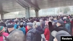Demonstrators gather outside Zhongshan park to protest changes to medical benefits in Wuhan, China, Feb. 15, 2023 in this still image from social media video.