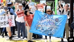 អ្នក​តវ៉ា​ម្នាក់​លើក​បដា​ក្នុង​អំឡុង​បាតុកម្ម​មួយ​ប្រឆាំង​នឹង​ការ​ចាប់​ផ្តើម​បង្ហូរ​ទឹក​​វិទ្យុសកម្ម​​ពី​​រោងចក្រ​នុយក្លេអ៊ែរ​ Fukushima Daiichi ​នៅ​មុខ​ទីស្នាក់ការ​នៃ​កនក្រុមហ៊ុន​ថាមពល​អគ្គិសនី​តូក្យូ​ កាល​ពី​ថ្ងៃ​ទី​២៤ ខែ​សីហា ឆ្នាំ​២០២៣។