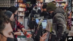 Store clerks and shoppers wear masks at Brooklyn's Park Slope Co-Op grocery store, Dec. 7, 2023, in New York.