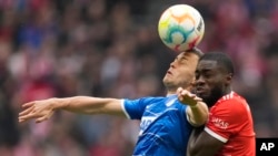 Hoffenheim's Christoph Baumgartner, left, jumps for a header with Bayern's Dayot Upamecano during the German Bundesliga soccer match between Bayern Munich and 1899 Hoffenheim in Munich, April 15, 2023.