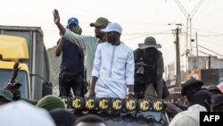 Ousmane Sonko (bras levé) et son bras droit Bassirou Diomaye Faye (chemise blanche) en campagne en Casamance.