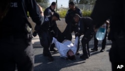 FILE - Israeli police officers remove an ultra-Orthodox Jewish man from the street during a protest against army recruitment in Jerusalem on June 2, 2024.
