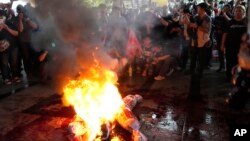 Supporters of Thailand's Move Forward Party burn an effigy during a protest at Pheu Thai party headquarters in Bangkok on Aug. 2, 2023.