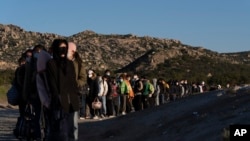 Chinese migrants wait to be processed after crossing the border with Mexico, May 8, 2024, near Jacumba Hot Springs, Calif.