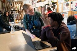 FILE - Art teacher Alyce Grunt speaks with a student at Penn Wood High School in Lansdowne, Pa., Wednesday, May 3, 2023. (AP Photo/Matt Rourke)