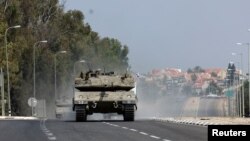 Israeli tanks drive on a road near Sderot in southern Israel, following a mass infiltration by Hamas gunmen from the Gaza Strip, Oct. 8, 2023. 