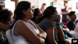 Migrants watch the US presidential debate in a shelter for migrants waiting to apply for asylum, June 27, 2024, in Tijuana, Mexico. 