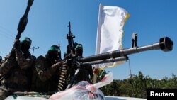 Palestinian fighters from the armed wing of Hamas take part in a military parade to mark the anniversary of the 2014 war with Israel, near the border in the central Gaza Strip, July 19, 2023. 