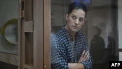 Wall Street Journal reporter Evan Gershkovich, arrested on espionage charges, stands inside a defendants' cage before a hearing to consider an appeal on his arrest at the Moscow City Court in Moscow, April 18, 2023.
