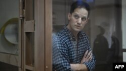 FILE - U.S. journalist Evan Gershkovich, arrested on espionage charges, stands in a defendants' cage at Moscow City Court in Moscow, April 18, 2023. The U.S. has called for Russia to immediately release Gershkovich after Moscow extended his pre-trial detention by three months.