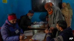 A polling official puts an ink mark on the finger of an elderly voter before he casts his vote during the fourth phase of India's general election, in Baba Nagri, northeast of Srinagar, Indian-administered Kashmir, May 13, 2024.