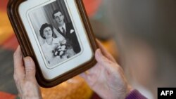 À Locmaria-Plouzané, dans le nord du Finistère, le 14 mars 2024, Jeanne Tournellec regarde la photographie de mariage montrant sa sœur Catherine Tournellec, violée, et son beau-frère, Eugène Tournellec, tué le 20 août 1944 par le soldat américain William Mack. 