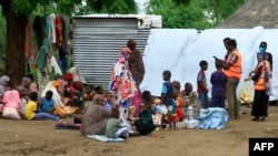 Sudanese, displaced from the town of Sinjah, receive humanitarian aid at their makeshift camp in the eastern city of Gedaref on Aug. 22, 2024.
