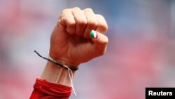 FILE - An Iranian woman runner with her thumbnail painted in the colors of the Iranian national flag clenches her fist after a race.