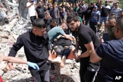 Palestinians remove the body of a man after a military operation in the Palestinians town of Deir al-Ghusun, near the West Bank town of Tulkarem, May 4, 2024.