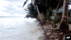 FILE - Waves surge over the beck and onto the island during a king tide event on Kili in the Marshall Islands, Jan. 21, 2015. (Bikini Atoll Local Government) 