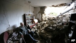 An elderly man sits inside a damaged house after shelling that, according to Russian officials in Donetsk, was conducted by Ukrainian forces, in Donetsk, the capital of Russian-controlled Donetsk region, eastern Ukraine, April 28, 2023.