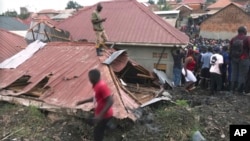 FILE - In this photo taken from video, people gather at a site of a collapsed landfill in Kampala, Uganda, Aug. 10, 2024. 