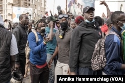 Protesters gather around the car carrying Ousmane Sonko to the courthouse in Dakar, Senegal, March 16, 2023.