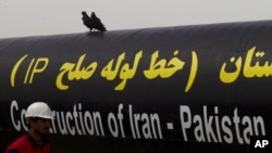 FILE - An Iranian worker walks past the Pakistan-Iran Gas Pipeline Project in Gabd near the Pakistani border in Iran, March 11, 2013.