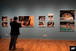 Seorang pengunjung melihat foto-foto di pameran Paul McCartney Photographs 1963-64: Eyes of the Storm di Inggris (dok: AP)