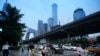 Pedestrians cross an intersection with the background of the central business district in Beijing, July 12, 2024. 