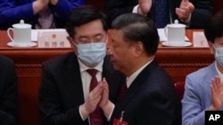 FILE - Chinese President Xi Jinping walks by then newly elected Chinese Foreign Minister Qin Gang during the closing ceremony for China's National People's Congress at the Great Hall of the People in Beijing, March 13, 2023.