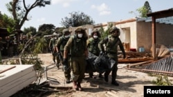 以色列士兵在以色列南部Kibbutz Kfar Aza地区抬着被巴勒斯坦武装分子杀害的以色列平民的遗体。（2023年10月10日）