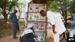 FILE - Men look at headlines from various newspapers in Bamako on June 11, 2021. Mali’s junta issued an order April 11, 2024, prohibiting all forms of media from reporting on activities of political groups.