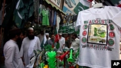 People visit a market in Peshawar, Pakistan, to buy national flags, badges and masks ahead of Pakistan Independence Day celebrations to be held on Aug. 14. Pakistan appointed a caretaker prime minister to run the country on Aug. 12, 2023.