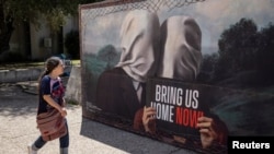 A woman walks next to a display in solidarity with hostages kidnapped during the deadly October 7 attack by the Palestinian Islamist group Hamas from Gaza, in Tel Aviv, Israel, May 31, 2024.