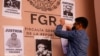 Un hombre coloca carteles que retratan a periodistas asesinados, durante una protesta que exige justicia y protección del gobierno federal tras los asesinatos de cinco colegas, frente a la oficina del Fiscal General en Ciudad Juárez, México, el 14 de febrero de 2022.