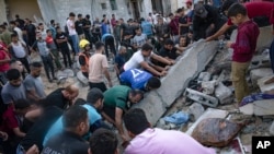 Palestinians look for survivors after Israeli airstrikes in Khan Younis, Gaza Strip, Oct. 16, 2023.