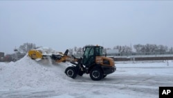 Un quitanieves despeja un estacionamiento en Pierre, Dakota del Sur, EEUU, el miércoles, 22 de febrero de 2023.
