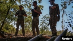 Ukrainian servicemen stand near artillery shells at a front line in Donetsk region, Ukraine, Sept. 22, 2023. Ukraine officials said on December 22 that they had uncovered a plot that involved the fraudulent purchase of shells and included the embezzlement of $40 million.