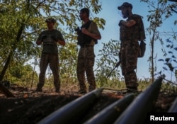 Ukrainian servicemen stand near artillery shells at a front line, amid Russia's attack on Ukraine, in Donetsk region, Ukraine, Sept. 22, 2023.