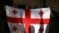Activists hold a Georgian flag at a rally outside a parliament building during a plenary session of parliament on the controversial "foreign agents" bill, that sparked mass protests in recent days, in Tbilisi, Georgia, March 10, 2023.