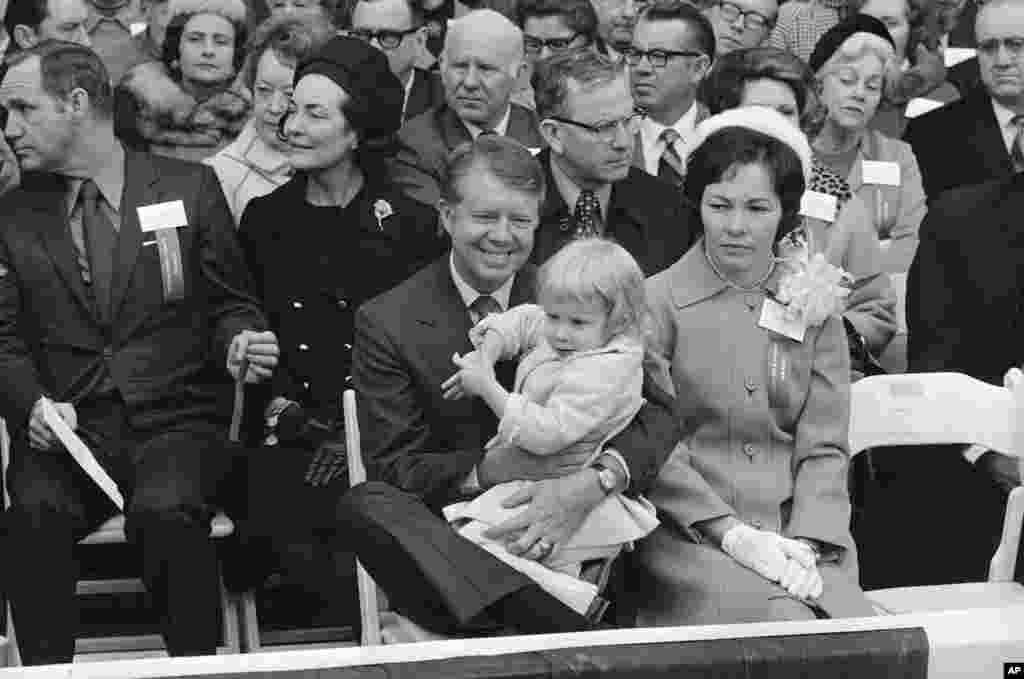 Gov. Jimmy Carter, holding daughter Amy, and Rosalynn Carter, right, listen while Lt. Gov. Lester Maddox makes his acceptance speech, Jan. 12, 1971, Atlanta, Georgia.