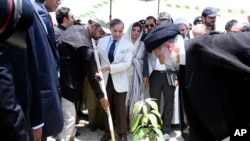 Iran's President Ebrahim Raisi, right, plants a mango tree with Pakistan's Prime Minister Shahbaz Sharif, center, during an inauguration of the Mand-Pishin border in Pishin, May 18, 2023. (Pakistan Prime Minister Office via AP)