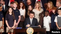 Florida Governor Ron DeSantis signs state house bills into law after giving a press conference at Cambridge Christian School in Tampa, Florida, May 17, 2023.